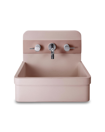 a pink sink with two faucets and a faucet